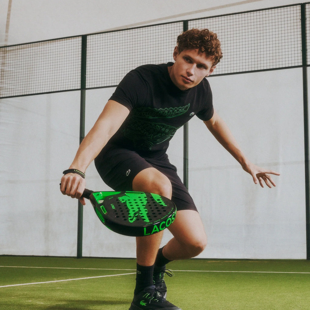 Lacoste L-Max green and black padel racket, on-court lifestyle view