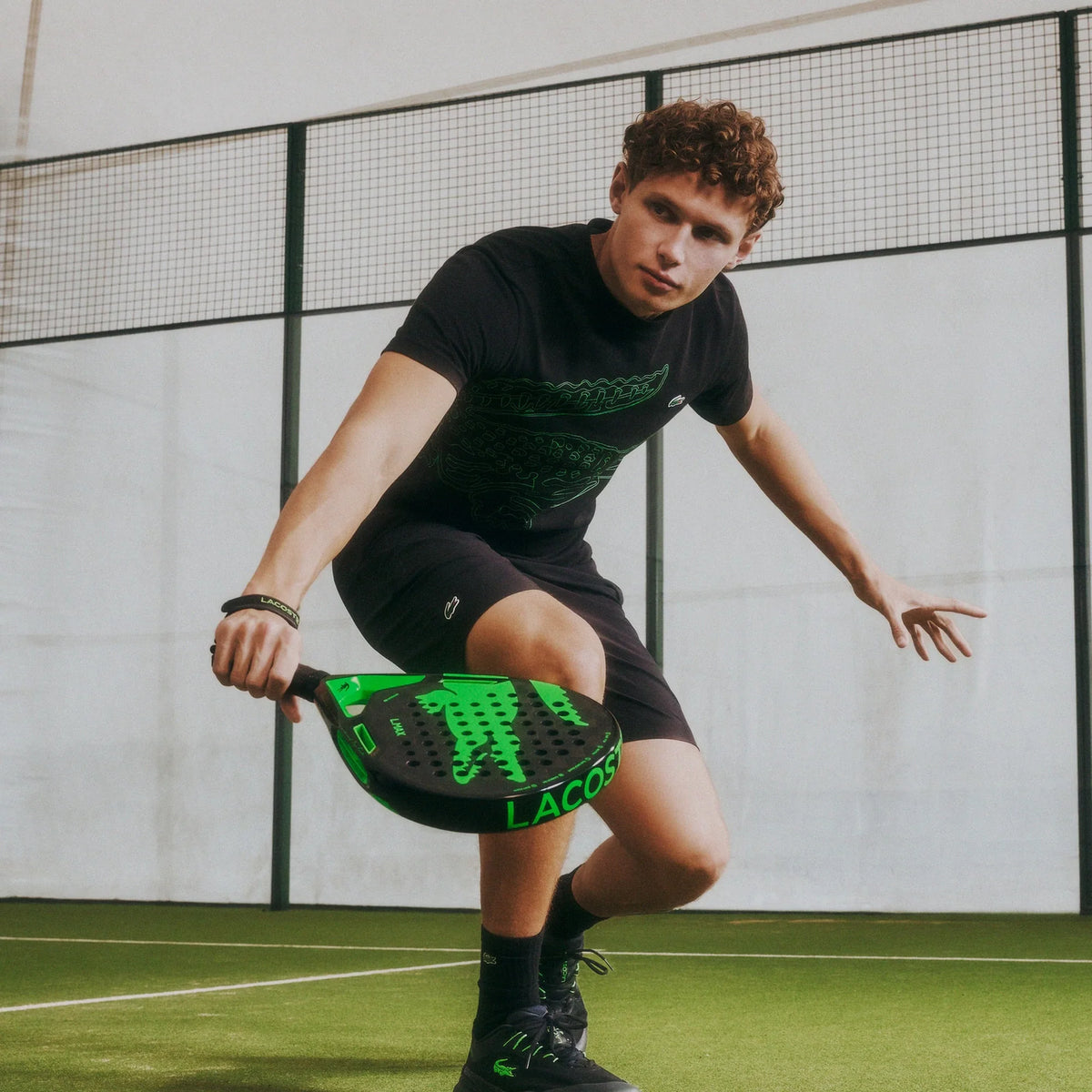 Lacoste L-Max green and black padel racket, on-court lifestyle view